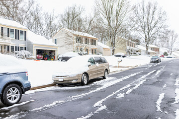 community neighborhood single family houses with cars on street covered in white snow in northern vi