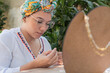 © Hector Pertuz - Woman making necklaces in her home workshop.