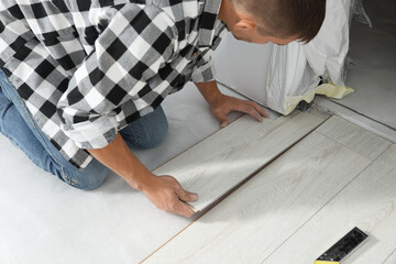 Wall Mural - Professional worker installing new laminate flooring indoors, closeup