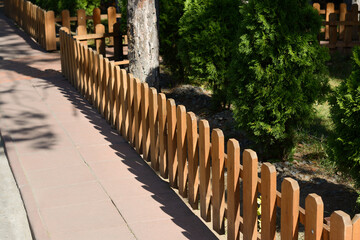 Sticker - Small wooden fence near thujas on sunny day outdoors