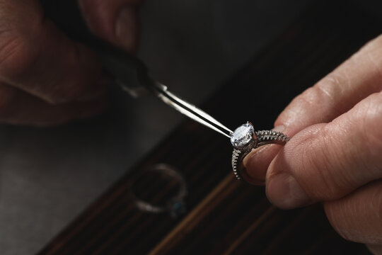 Wall Mural - Professional jeweler working with ring at table, closeup