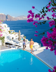 Wall Mural - Couple on vacation in Santorini Greece, men, and women relaxing by a swimming pool of a luxury resort during summer vacation
