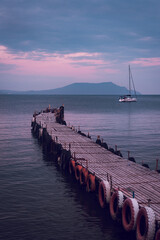 Sticker - Old wooden fishing pier goes into the sea on sunset. Resort city Novyi Svet, Crimea