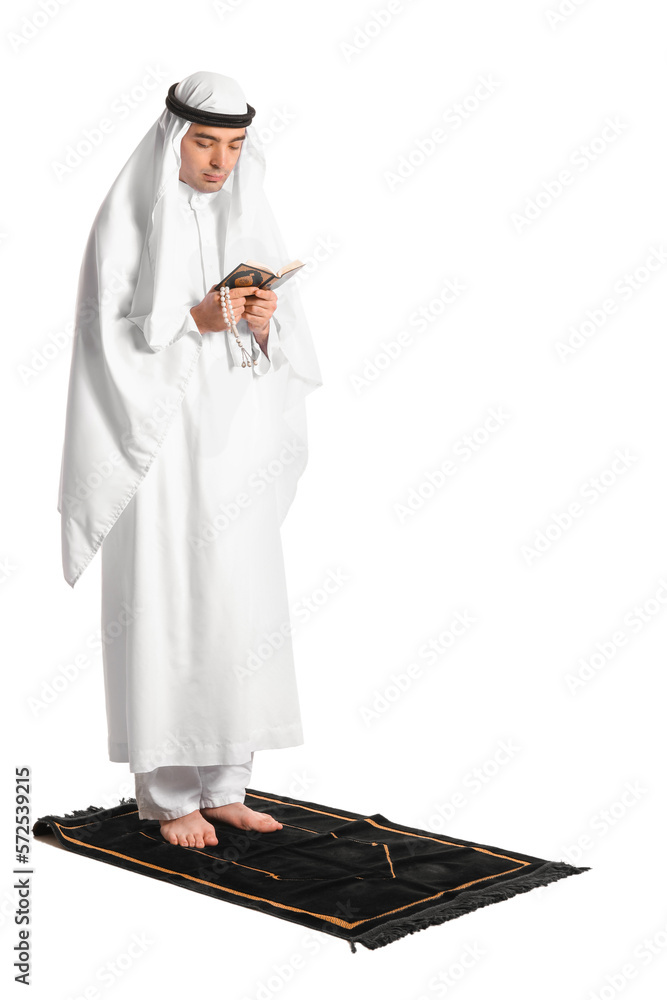 Praying Muslim man with Koran on white background