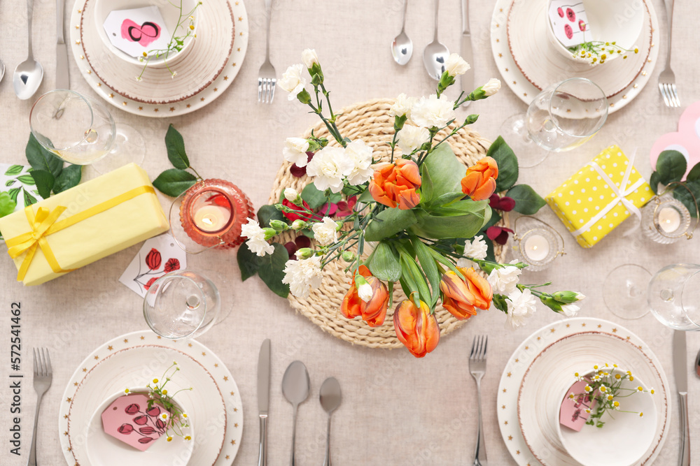 Setting for International Women's Day celebration with flowers and gift boxes on table
