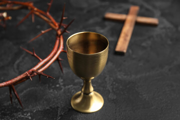 Wall Mural - Wine cup, crown of thorns and cross on dark background, closeup