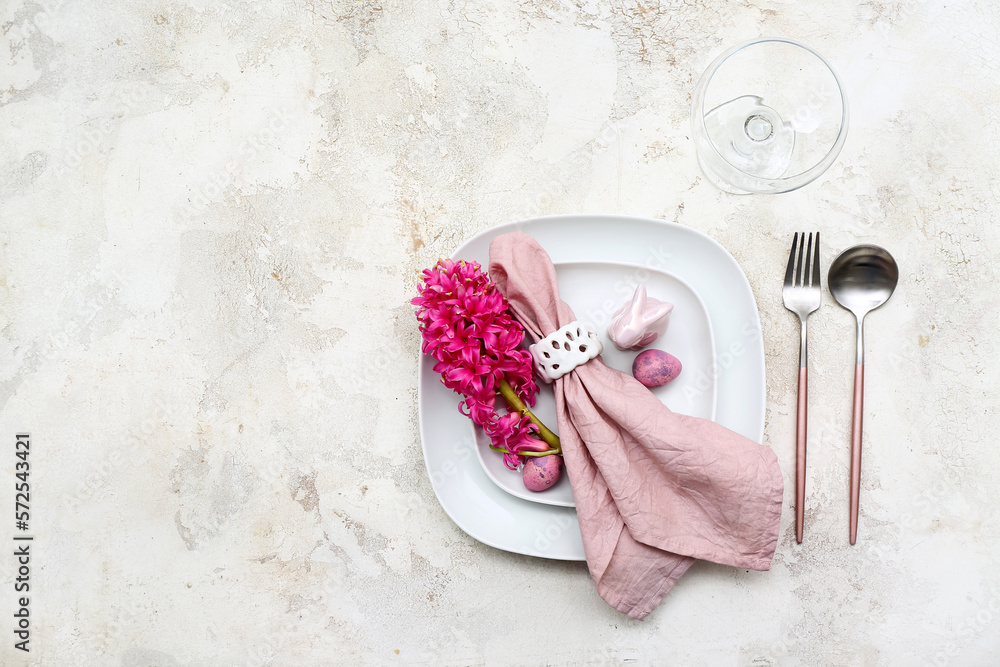 Table setting with Easter eggs, hyacinth flowers and bunny on white background