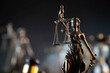 © zolnierek - Law and justice concept. War crimes. Gavel and Themis sculpture in lawyers office. Gray bokeh background.