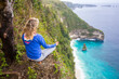 © Cavan Images - Blonde woman meditating on edge of coastline cliff, Bali, Indonesia