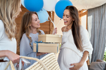 Group of caucasian women giving gifts to friend in pregnant