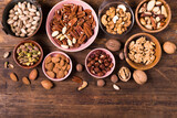 top view, on an old wooden background, a large assortment of dried fruits placed in various bowls and on the table.