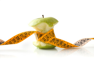 Wall Mural - Half eaten apple and tape measure strangling it isolated background