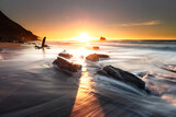 Fototapeta Uliczki - Sunset while sea waves hitting the rocks on the beach; at Ilbarritz beach in Biarritz, Basque Country.