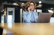 © Jacob Lund - Calling clients on a mobile phone. Professional business woman talking on a phone call