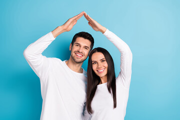 Sticker - Photo portrait of cute young man woman arms showing house roof mortgage rent wear trendy white garment isolated on blue color background