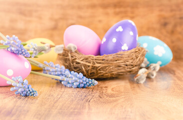  Defocused Easter eggs and spring flowers on wooden table. Background. Easter concept.