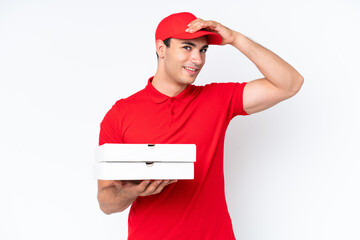 Wall Mural - Pizza delivery caucasian man with work uniform picking up pizza boxes isolated on white background doing surprise gesture while looking to the side