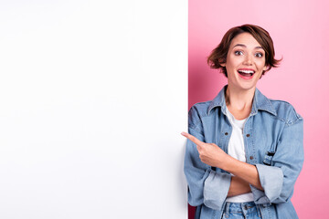 Portrait of astonished lady indicate finger empty space news blank isolated on pink color background