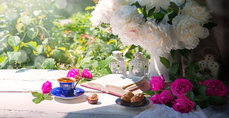 Wall Mural - Bible and a bouquet of peonies on a table in the garden