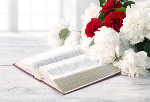 Bible and a bouquet of peonies on a table