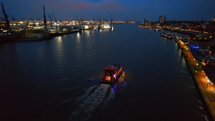 Wall Mural - Aerial drone view of a floating boat in Hamburg at evening, Germany. Elbe coastline, floating boat, sea port, classic and modern buildings, roads with cars and nightlights