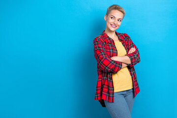 Photo of optimistic pretty girl with short hairstyle dressed red shirt arms folded look empty space isolated on blue color background