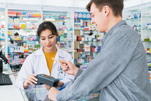 Payment By Credit Card With Payment Terminal In Qualified Drugstore. Modern Financial Payment Of Electric Money. Caucasian Customer Purchase Medication In Pharmacy With Prescription From Pharmacist.