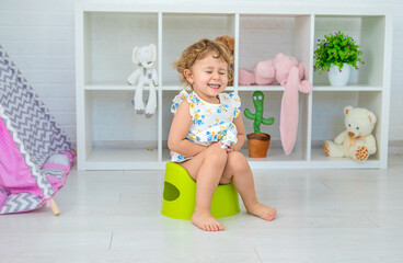 The child sits on the potty. Selective focus.