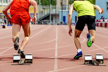 Wall Mural - two runners athletes start from starting blocks