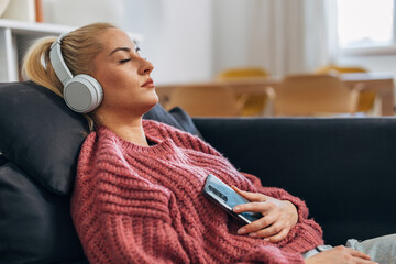 Wall Mural - Side view of a blond woman resting with music