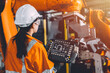 © Quality Stock Arts - Engineer team service robot welding working in automation factory. Woman worker operate robotic arm software hand controller in automated manufacturing industry technology.