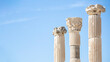 Three columns with corinthian capitals (partially ruined) in Ancient Ephesus. Sky an background. Selected focus, copy space. Art, design or tourism concept. Selcuk, Turkey (Turkiye)