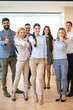 © Bojan - Full length of large group of confident business people showing thumbs up standing close to each other and smiling at office. Successful business team.