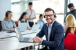 © Bojan - Portrait of handsome business man agent wearing headset working on laptop in call center office.