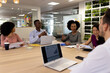 © WavebreakMediaMicro - Diverse female and male businesspeople with laptops sitting at desk and talking