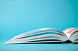 Open white book on a turquoise background