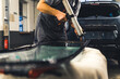 Mechanic adding glue to the windscreen of a car windshield replacement station. High-quality photo.