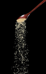 Wall Mural - Brown Sugar fall, brown grain sugar pouring down abstract cloud fly from wooden spoon. Beautiful complete seed sugarcane, food object design. Selective focus freeze shot Black background isolated