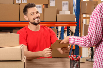 Canvas Print - Woman receiving parcel from worker at post office