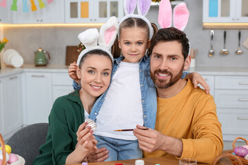 Canvas Print - Happy family with Easter eggs at table in kitchen