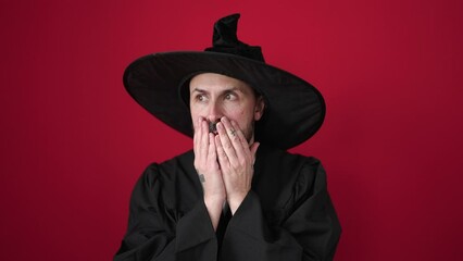 Canvas Print - Young bald man wearing wizard costume standing with fear expression over isolated red background