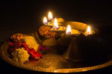 panch pradeep or five headed oil lamp burning with glowing flame with marigold flowers. these are used in hindu puja rituals like durga , saraswati , kali , laxmi puja, shivaratri, holi or diwali.