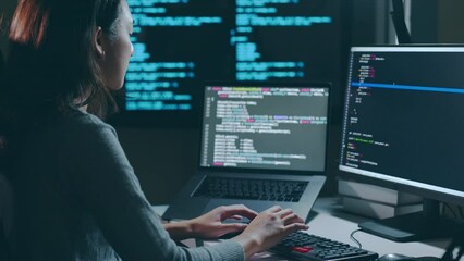Young Asian woman, developer programmer, software engineer, IT support, working hard at night overtime on computer to check coding in bugging system