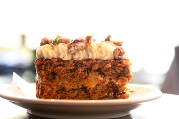 Wall Mural - Carrot cake with walnuts, prunes and dried apricots with little edible flower.