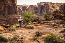 A Man Mountain Biking In A Dramatic Desert Environment.