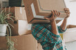 © simona - One woman lifting up heavy cardboard box during relocation moving house activity alone. Mortgage. New beginnings adventure female people single lifestyle. Changing life. Home indoors lifestyle people