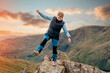 © Iryna - Woman reaching the destination and on the top of mountain against cloudy blue sky on autumn day Travel Lifestyle concept The national park Lake District in England