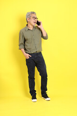 Wall Mural - The 40s adult Asian man with casual dressed standing on the yellow background.