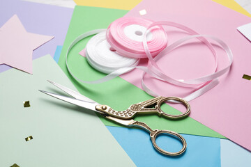 Canvas Print - Pair of scissors near ribbons on colorful paper sheets, closeup