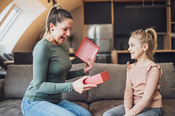 Happy mother is getting gift from her daughter.	